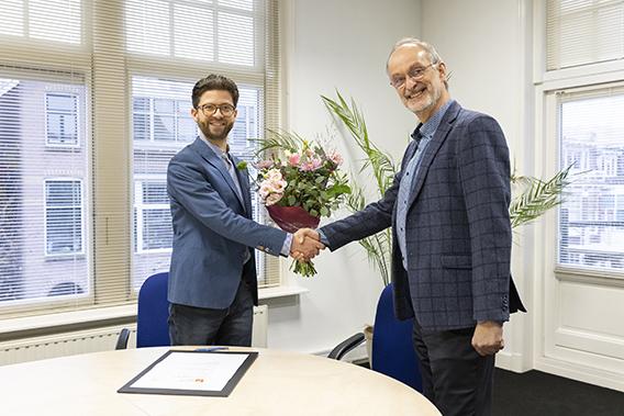 AMN-directeur Wouter van der Neut ontvangt bloemen en felicitaties van Paul Gillijns (Mediafederatie)