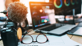 beeldschermen, microfoon en opname-apparatuur, bril op bureau